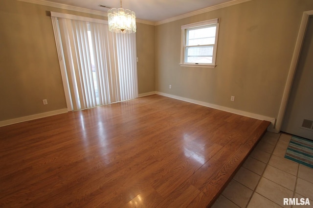 unfurnished room with a notable chandelier, ornamental molding, and tile patterned flooring