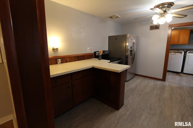 kitchen featuring kitchen peninsula, stainless steel fridge, hardwood / wood-style flooring, electric stove, and separate washer and dryer