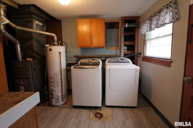 clothes washing area featuring cabinets, washer and clothes dryer, gas water heater, and electric panel