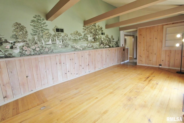 interior space with light hardwood / wood-style floors and lofted ceiling with beams