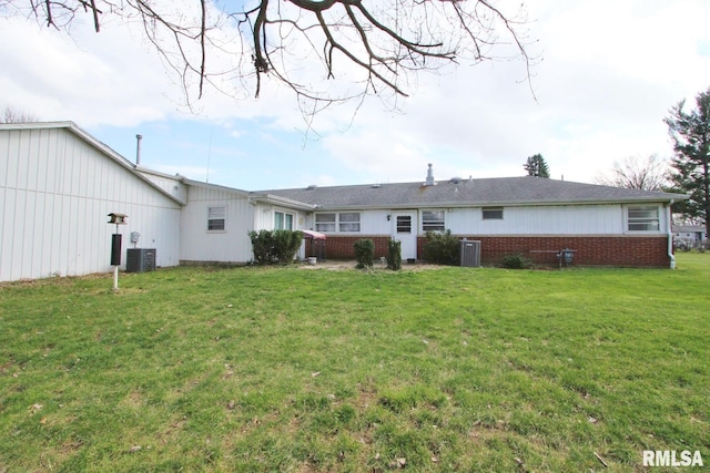 back of property with central air condition unit and a lawn