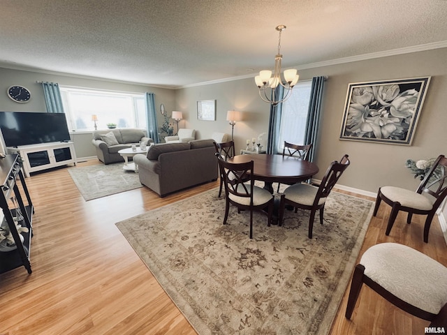 dining area with a textured ceiling, crown molding, hardwood / wood-style floors, and a notable chandelier