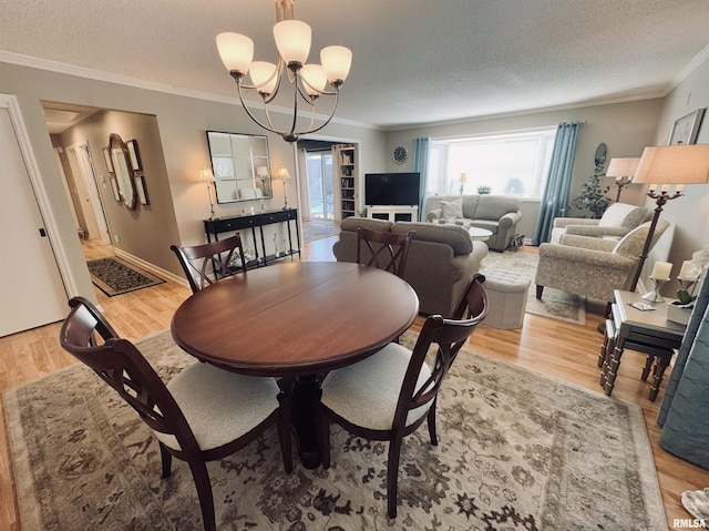 dining space with crown molding, an inviting chandelier, a textured ceiling, and hardwood / wood-style flooring