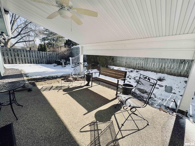 snow covered patio featuring ceiling fan