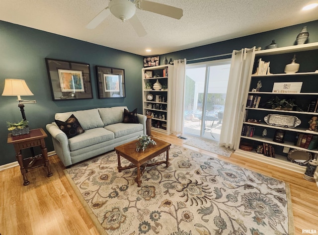 living room featuring a textured ceiling, ceiling fan, and wood-type flooring