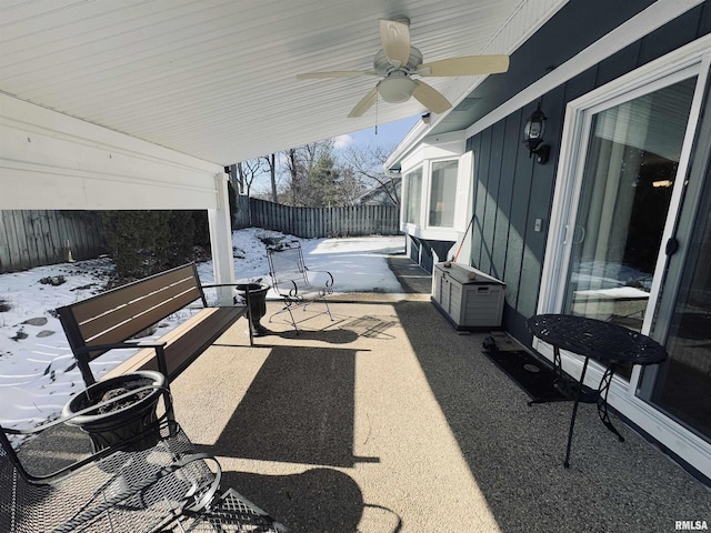 snow covered patio featuring ceiling fan and cooling unit