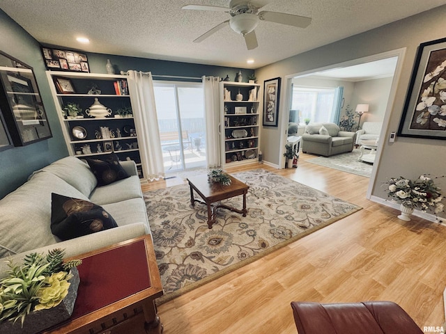 living room featuring a textured ceiling, ceiling fan, and hardwood / wood-style floors