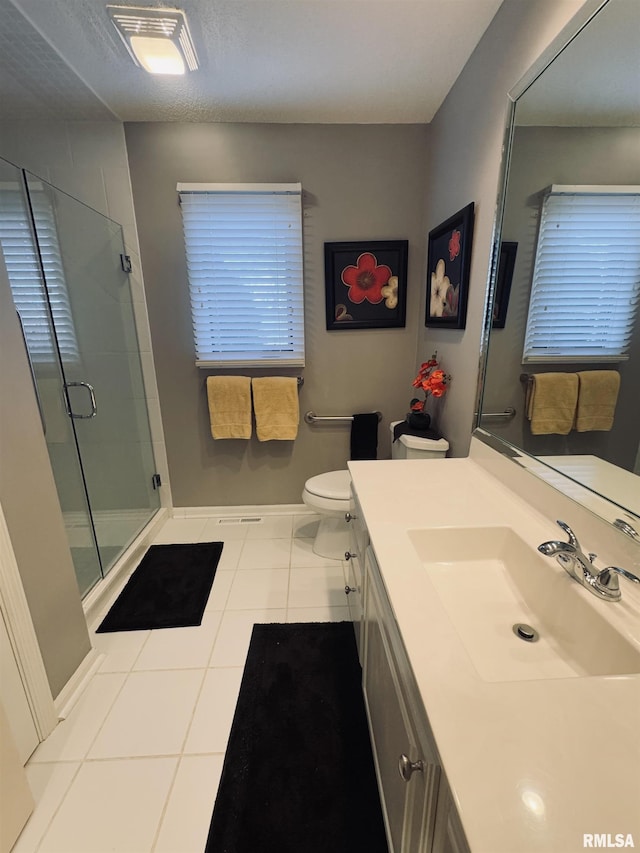 bathroom with vanity, toilet, tile patterned flooring, and an enclosed shower