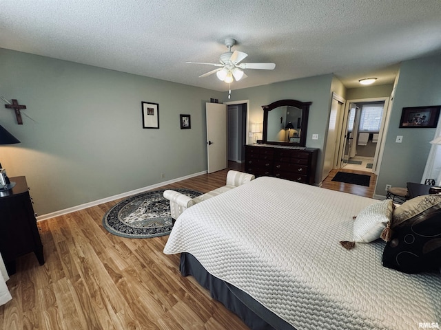 bedroom featuring a textured ceiling, ceiling fan, and wood-type flooring