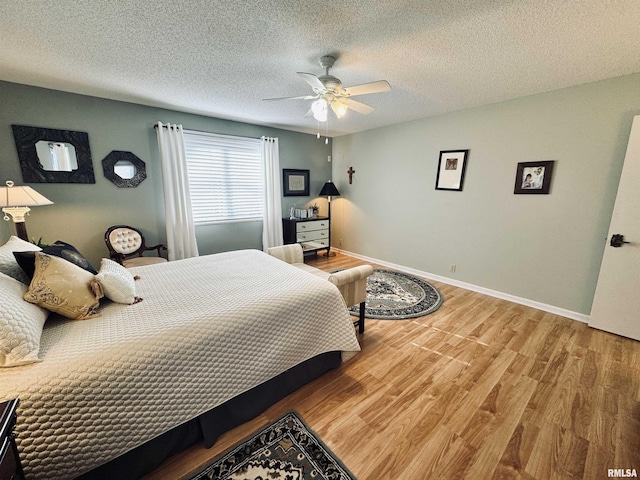 bedroom featuring ceiling fan, a textured ceiling, and wood-type flooring