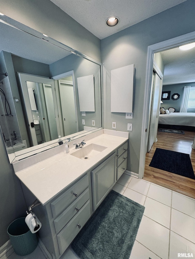 bathroom with vanity, tile patterned flooring, bathing tub / shower combination, and a textured ceiling