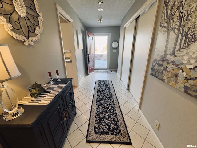 corridor featuring a textured ceiling and light tile patterned floors