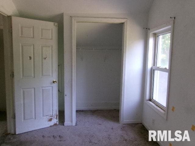 unfurnished bedroom featuring light colored carpet and a closet