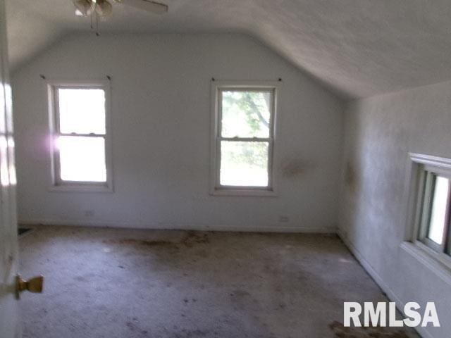 additional living space featuring lofted ceiling, light colored carpet, and ceiling fan