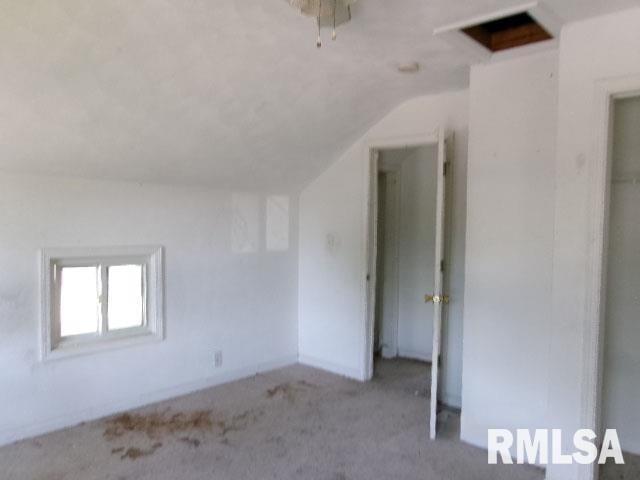 interior space featuring light colored carpet and vaulted ceiling