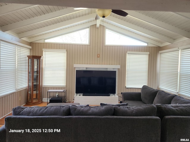 living room with vaulted ceiling with beams, ceiling fan, hardwood / wood-style flooring, and wood walls