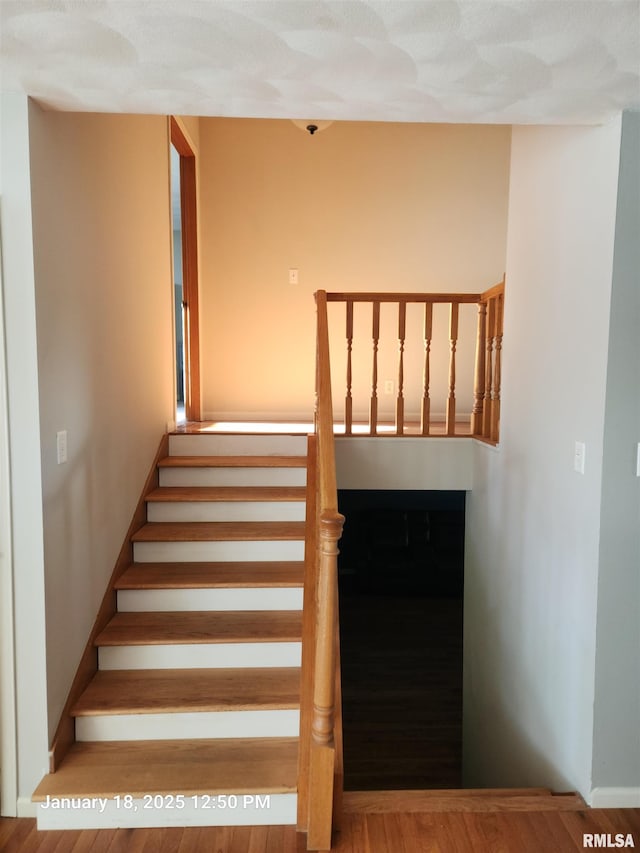 stairs featuring hardwood / wood-style flooring