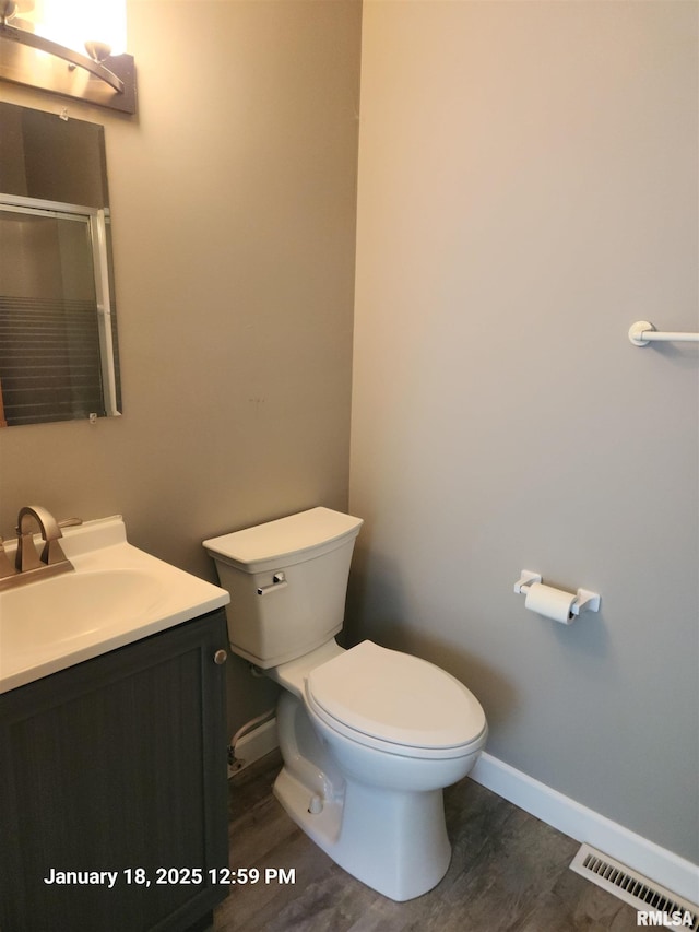 bathroom featuring hardwood / wood-style flooring, vanity, toilet, and an enclosed shower