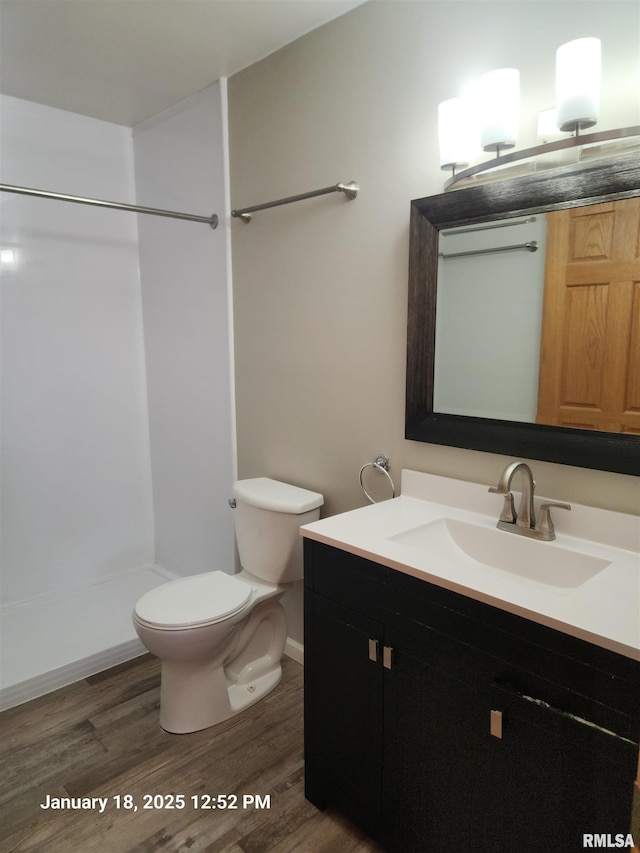 bathroom featuring vanity, hardwood / wood-style flooring, toilet, and walk in shower