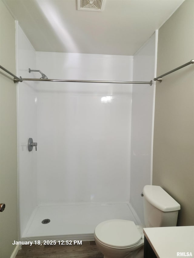 bathroom featuring walk in shower, vanity, and toilet