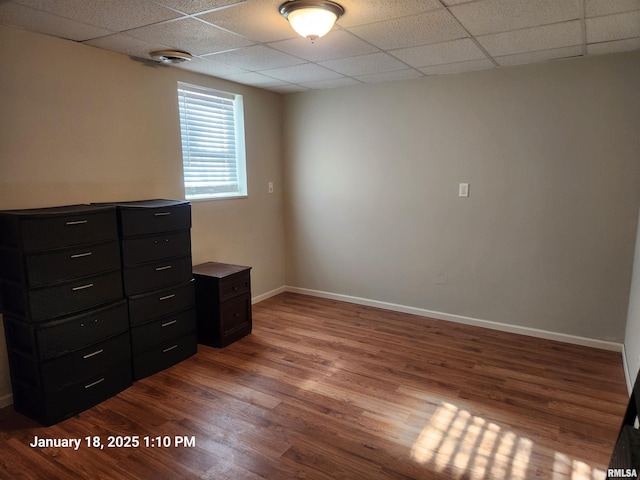 empty room with hardwood / wood-style floors and a paneled ceiling