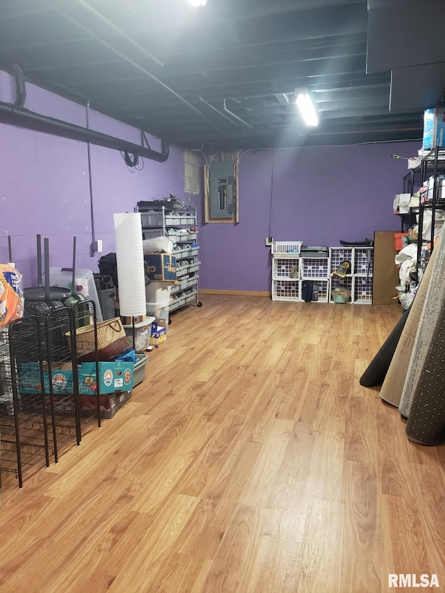 basement featuring electric panel and hardwood / wood-style floors