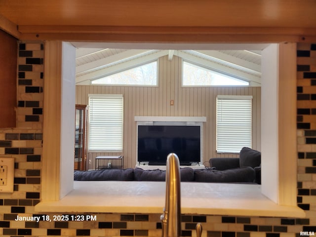 living room with lofted ceiling with beams