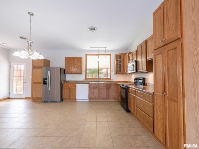 kitchen featuring an inviting chandelier, light tile patterned floors, stainless steel appliances, hanging light fixtures, and sink