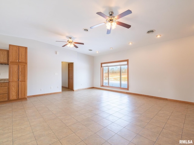 tiled empty room featuring ceiling fan