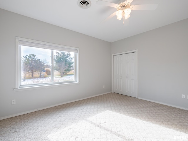 unfurnished bedroom featuring carpet floors, a closet, and ceiling fan