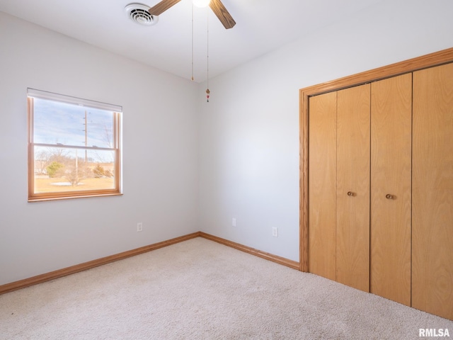 unfurnished bedroom featuring ceiling fan, a closet, and light carpet