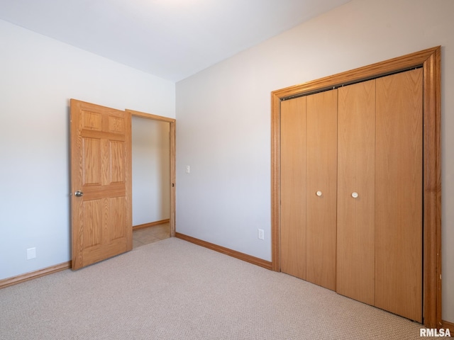 unfurnished bedroom featuring light colored carpet and a closet