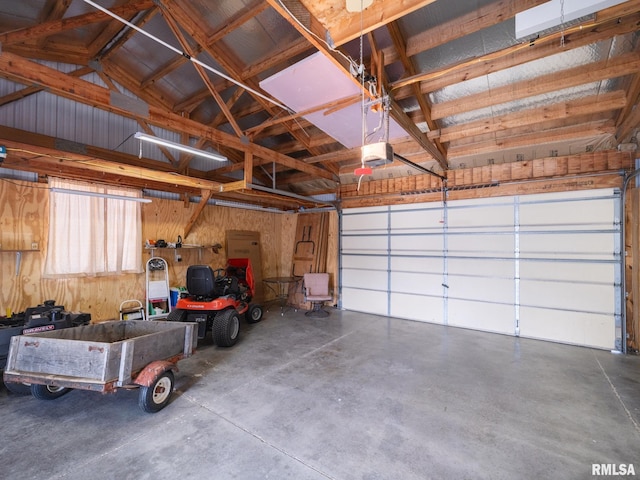 garage featuring a garage door opener and wooden walls