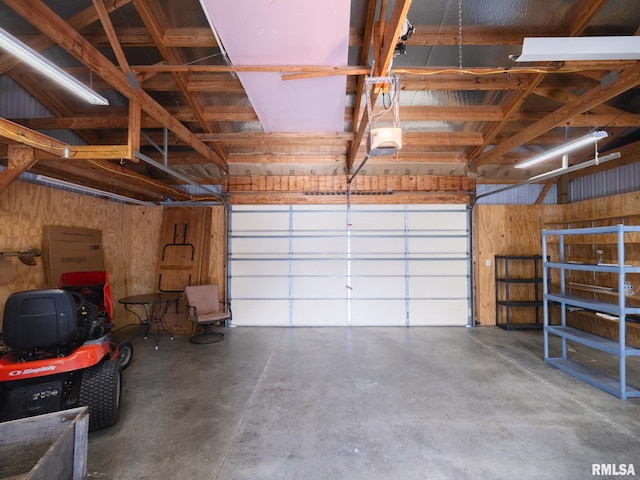 garage featuring a garage door opener and wood walls