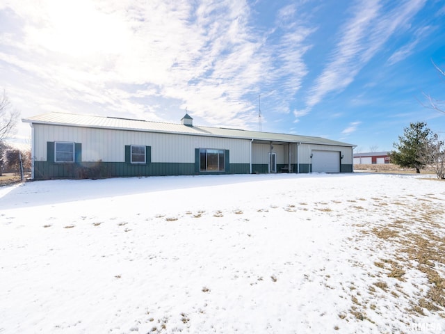 snow covered house featuring a garage