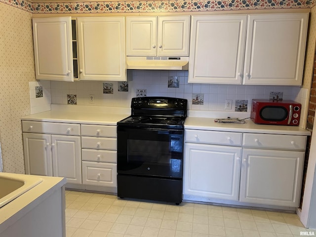 kitchen featuring tasteful backsplash, white cabinets, and electric range