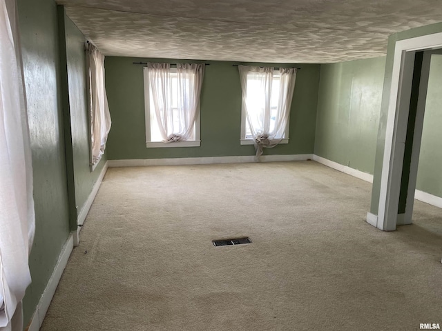 carpeted spare room with a textured ceiling