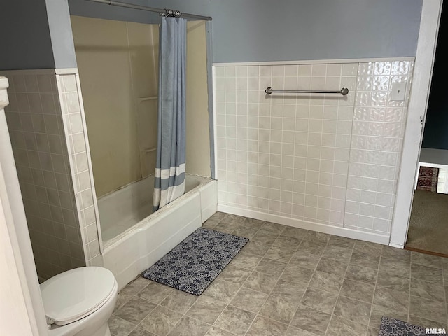 bathroom with tile walls, toilet, and shower / tub combo with curtain