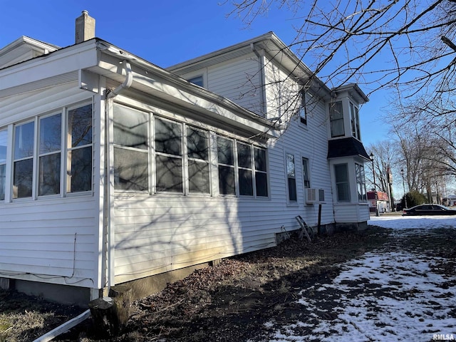 snow covered property with cooling unit