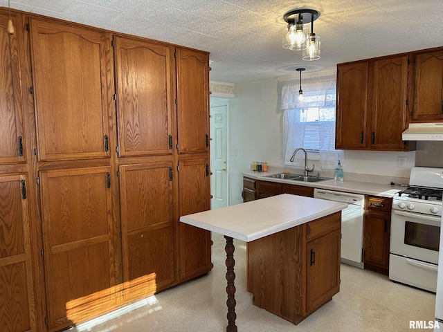 kitchen featuring decorative light fixtures, sink, white appliances, and a center island