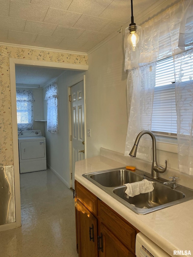 kitchen featuring hanging light fixtures, a healthy amount of sunlight, washer / clothes dryer, and sink