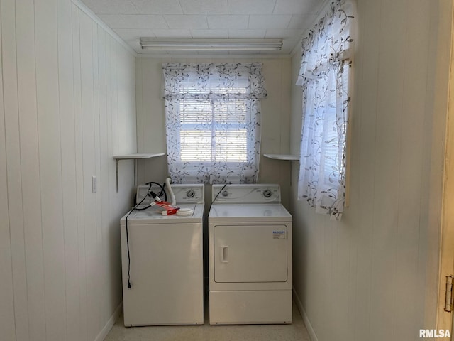 laundry area featuring washing machine and dryer, wooden walls, and ornamental molding