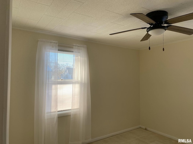 empty room with ceiling fan, a wealth of natural light, and ornamental molding