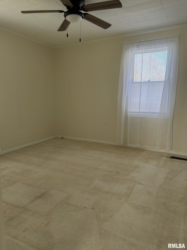 spare room featuring light carpet, ceiling fan, and ornamental molding