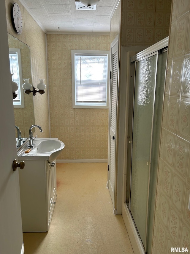 bathroom featuring walk in shower, vanity, and crown molding