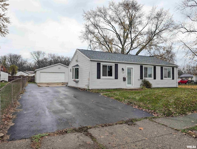 view of front facade with a garage, a front lawn, and an outbuilding