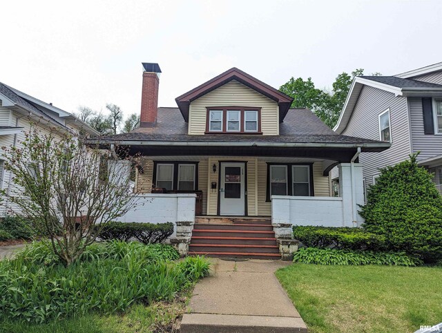 bungalow-style home with a porch and a front lawn