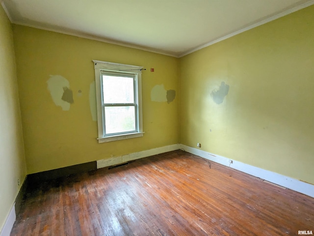 spare room featuring crown molding and dark hardwood / wood-style floors