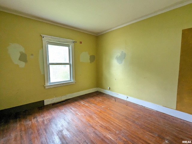 empty room featuring crown molding and hardwood / wood-style floors