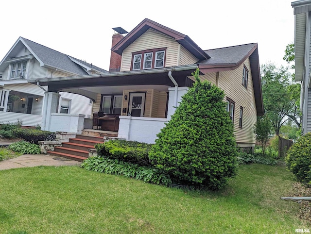 view of front of home with covered porch and a front lawn